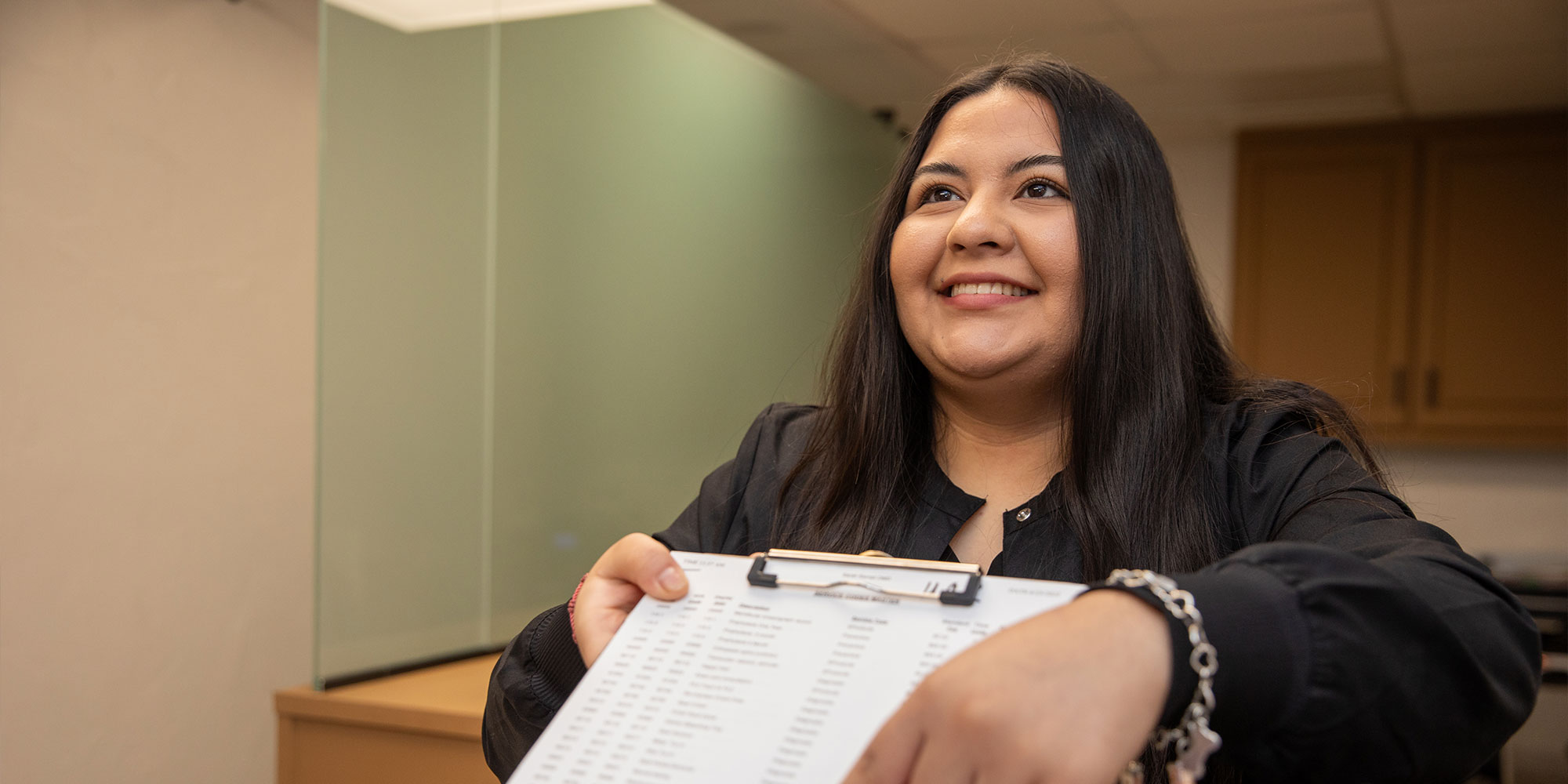 team member handing Patient insurance papers